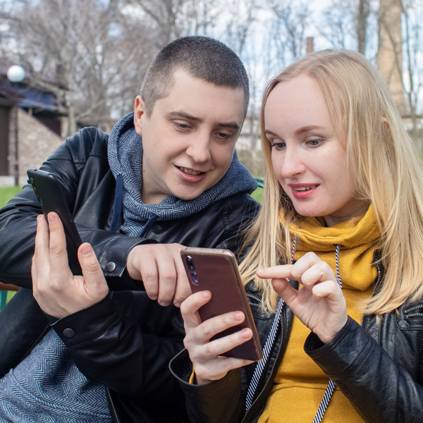 Two people looking at a mobile phone 