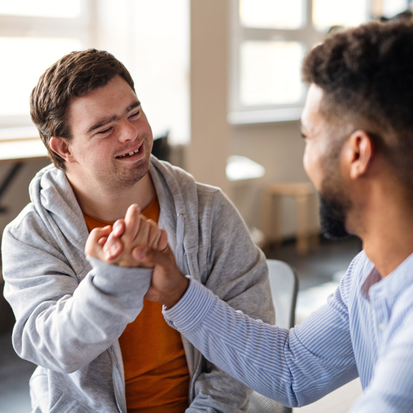 Carer and patient smiling and shaking hands