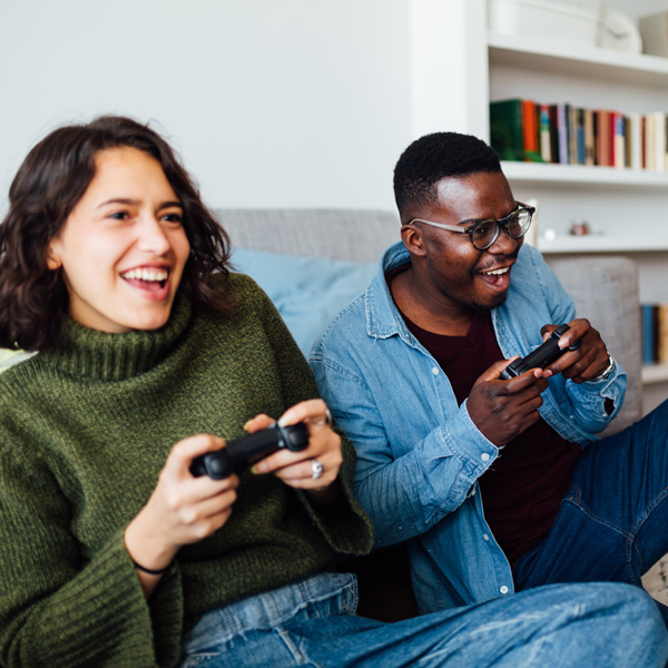 Two people laughing and playing video games